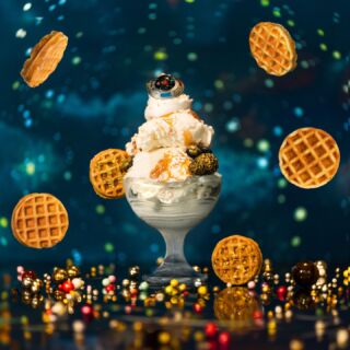 A festive sundae with waffles and sprinkles floating on a sparkling blue background.